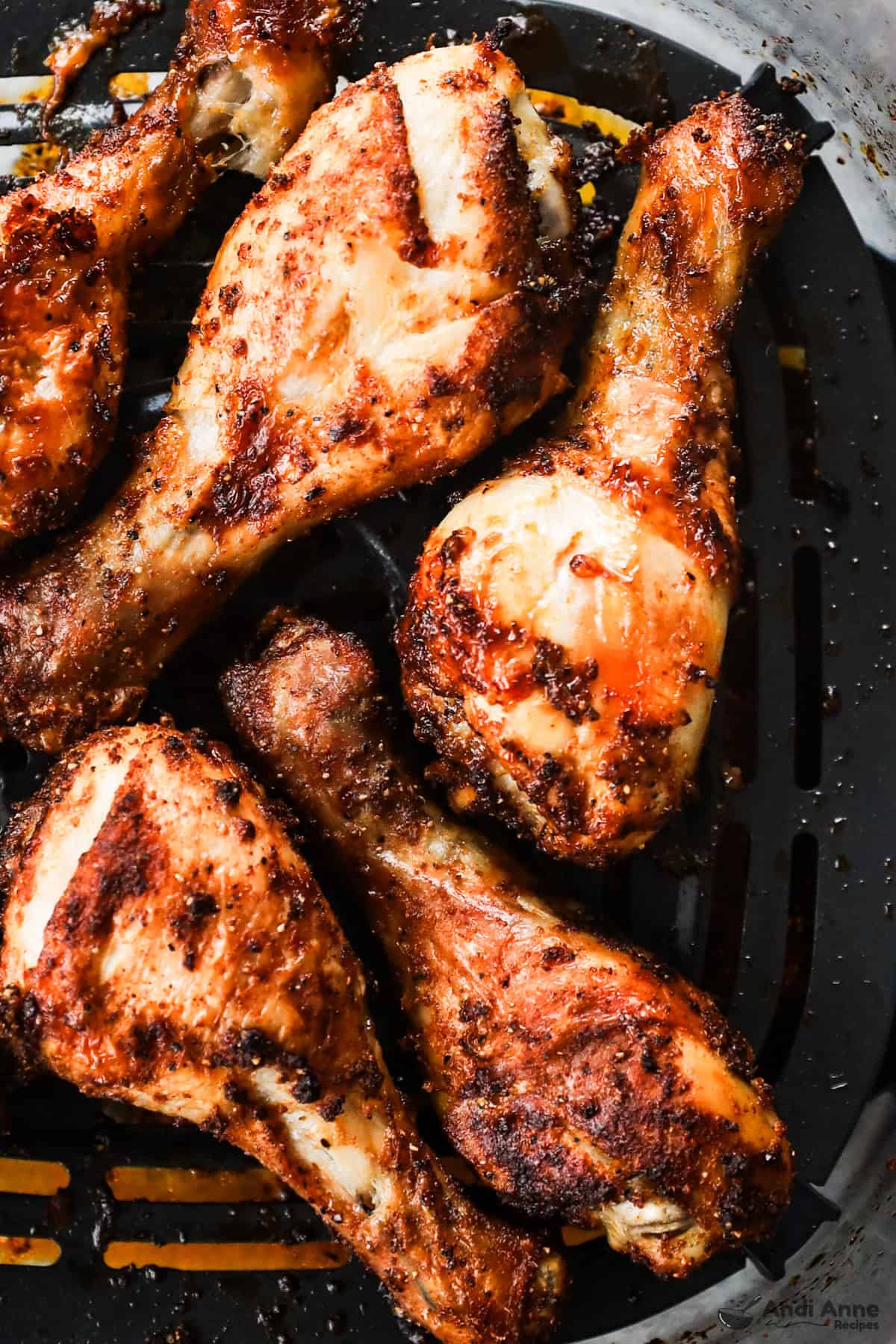 air fryer basket with cooked chicken legs