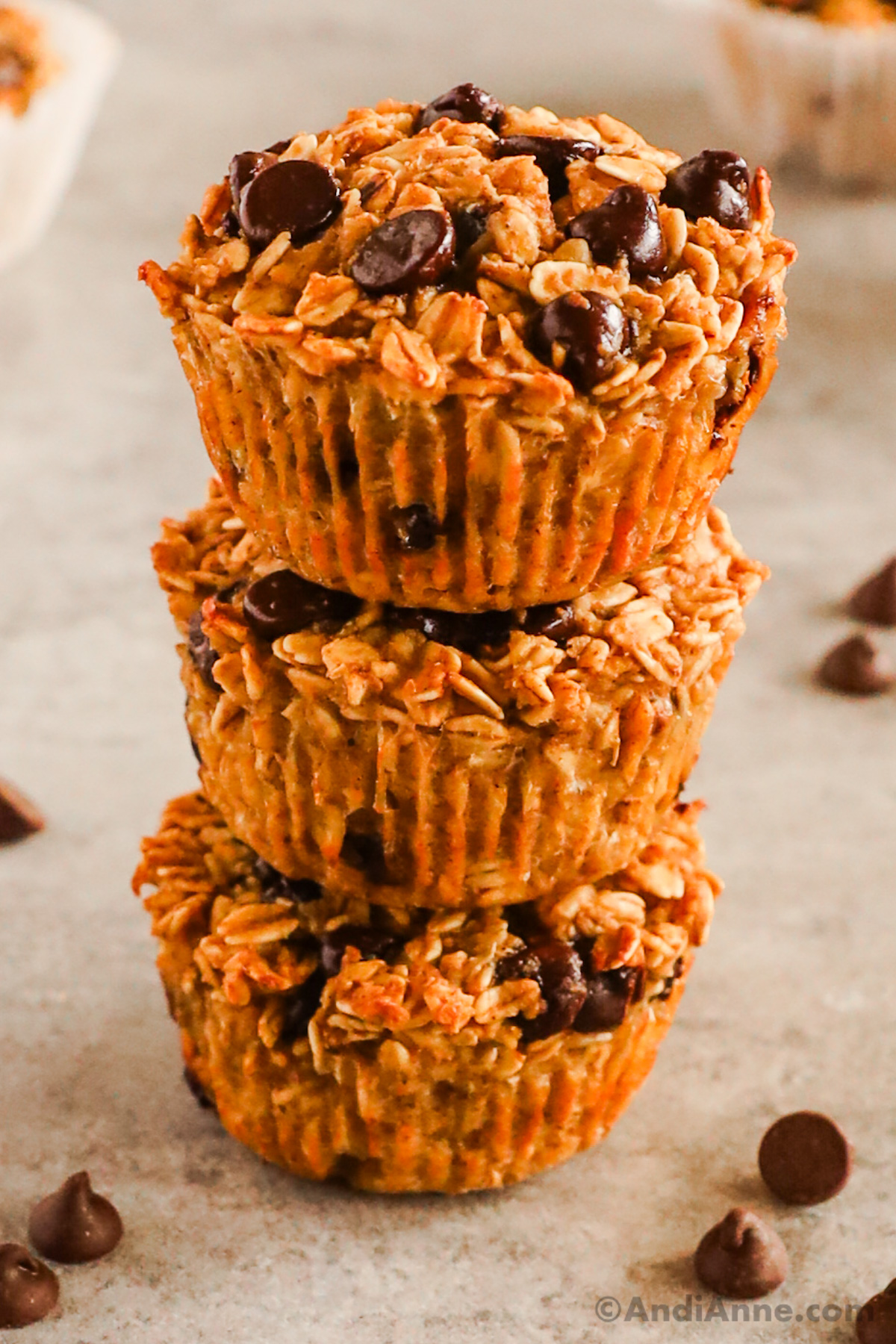 A stack of three chocolate chip muffin cups on top of eachother.