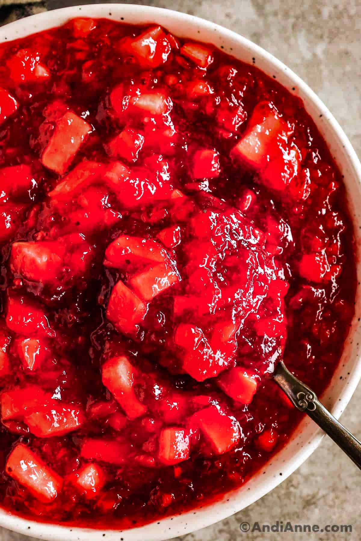bowl of cranberry jello salad with a spoon