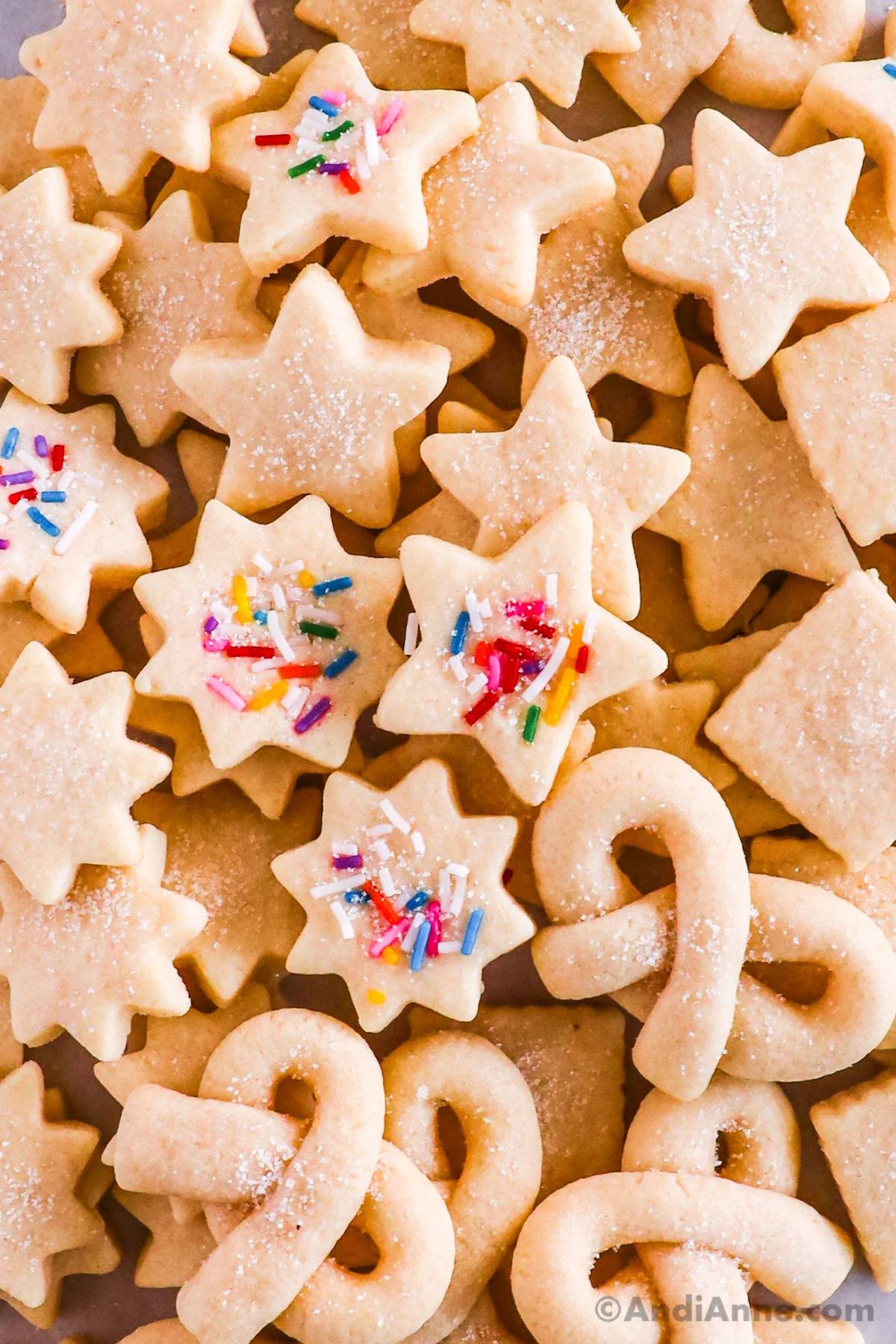 Close up of butter cookies in various shapes, some with sprinkles pressed in. 