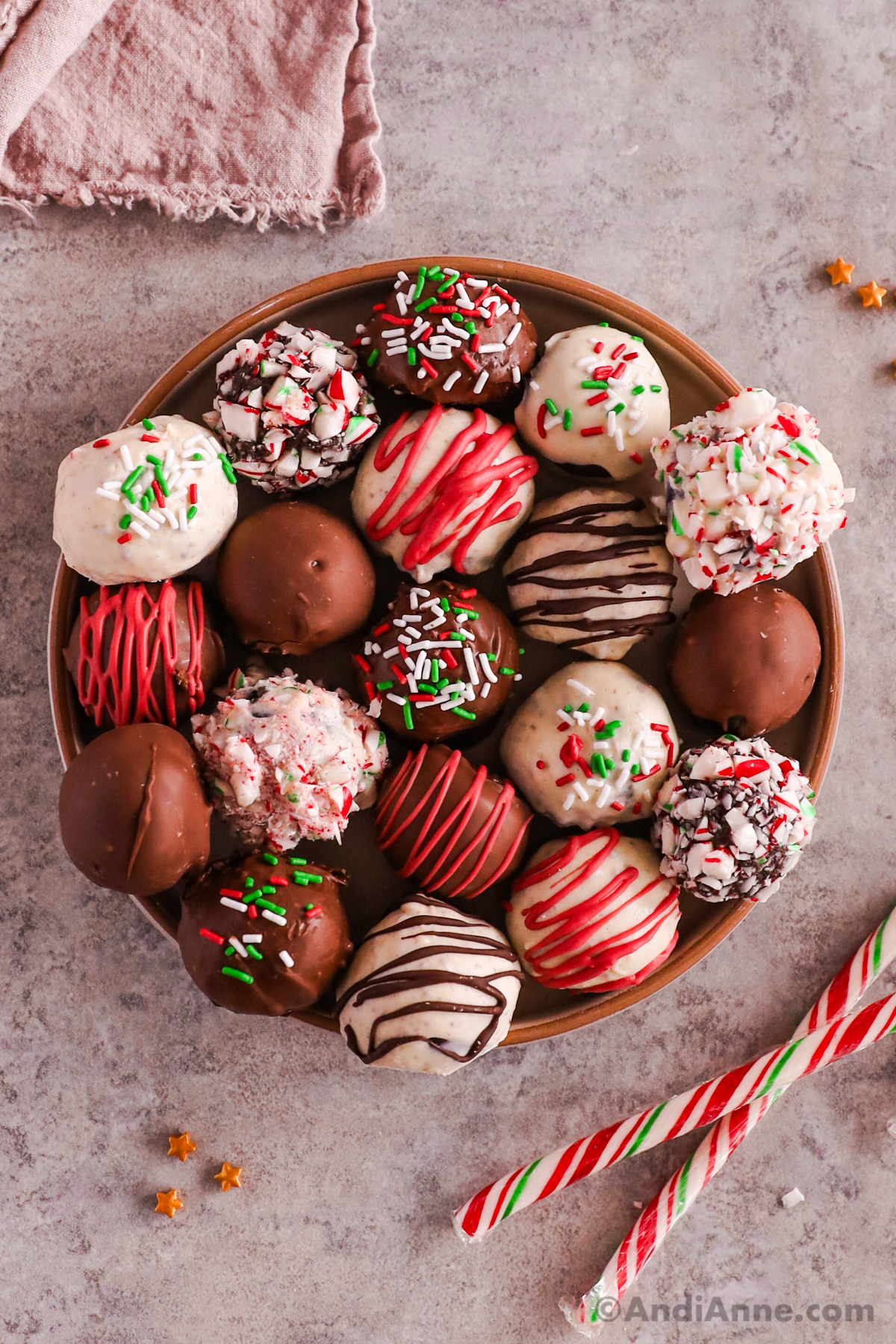 A plate of Oreo truffle balls, some white chocolate some milk chocolate. Some with sprinkles or crushed candy canes, some dipped with chocolate.