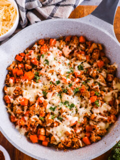 Ground turkey sweet potato recipe with melted cheese on top in a frying pan