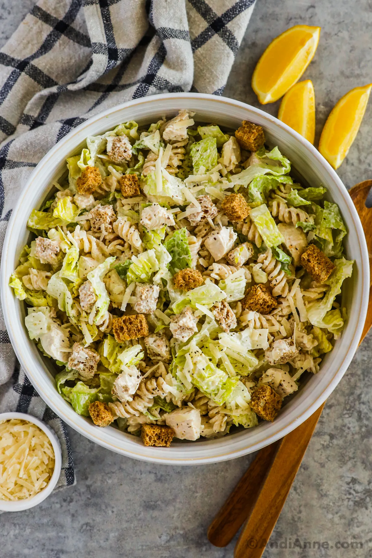 A bowl of creamy chicken pasta salad with croutons, rotini pasta, chopped chicken and lettuce.