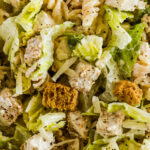 Close up of chicken caesar pasta salad recipe with croutons, lettuce, chicken and rotini pasta