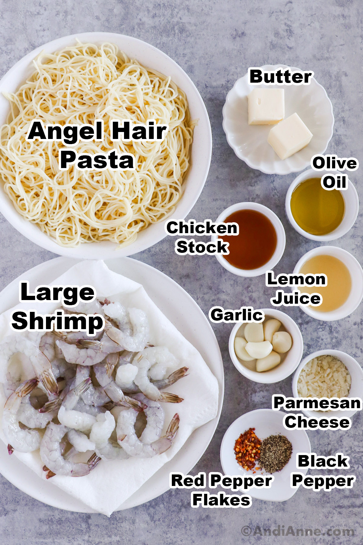 Recipe ingredients in bowls including raw shrimp, cooked angel hair pasta, butter, chicken stock, olive oil, lemon juice, garlic cloves and parmesan cheese.