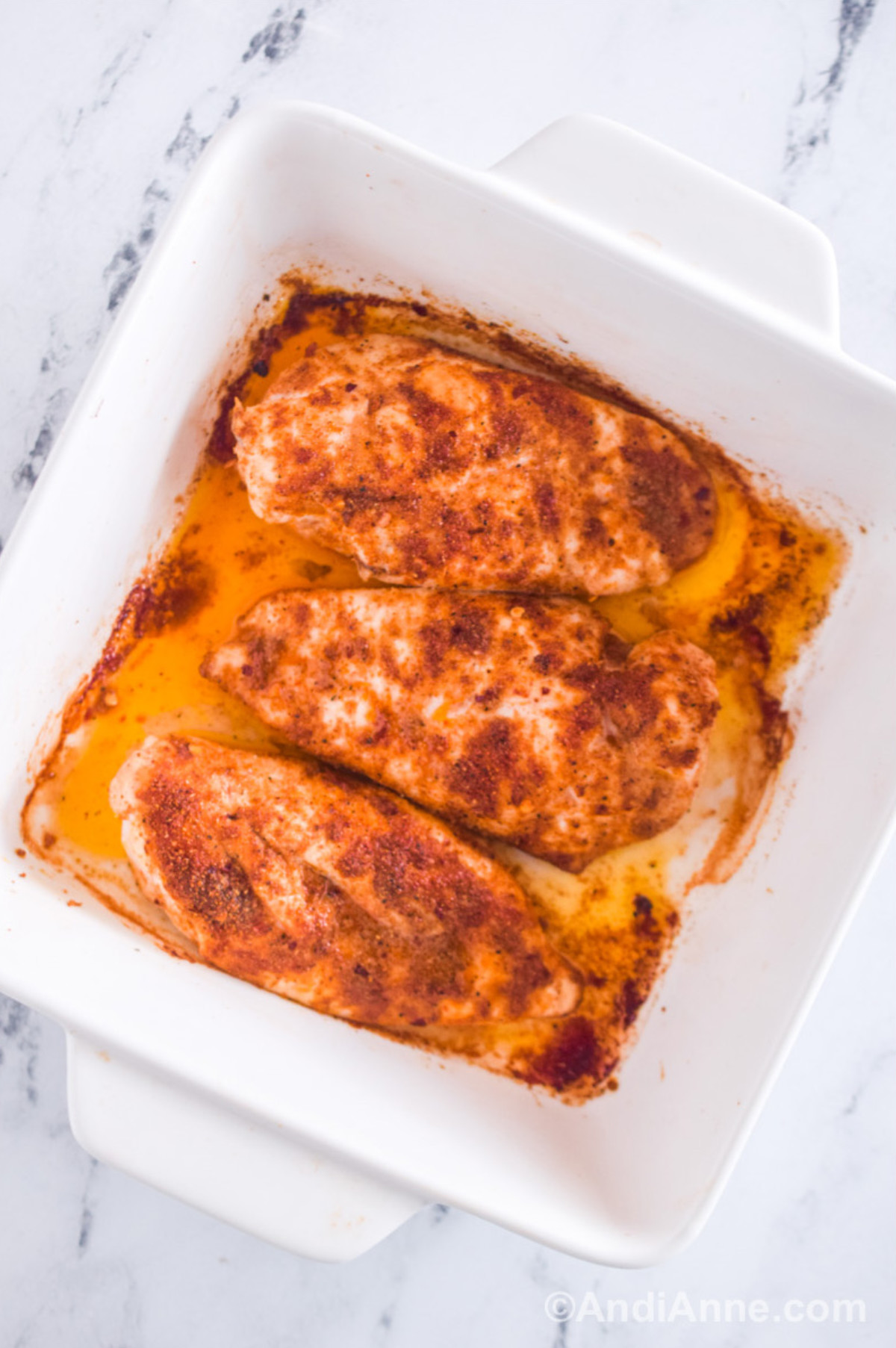 Closeup of cooked chicken breasts in casserole dish. 