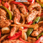 Close up of sliced chicken and bell peppers in easy chicken sheet pan fajitas recipe
