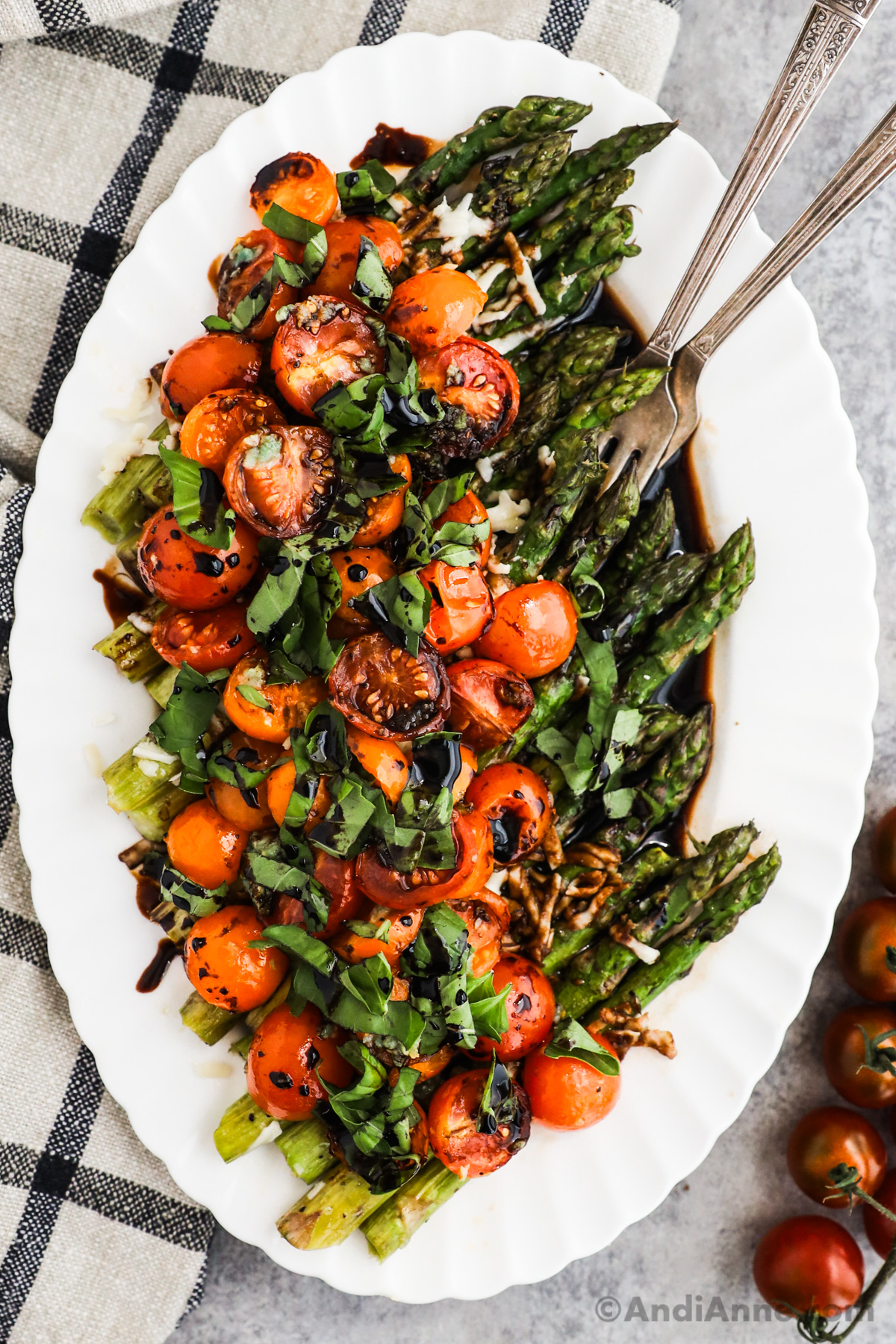 Asparagus and tomatoes in a balsamic parmesan sauce on a white dish