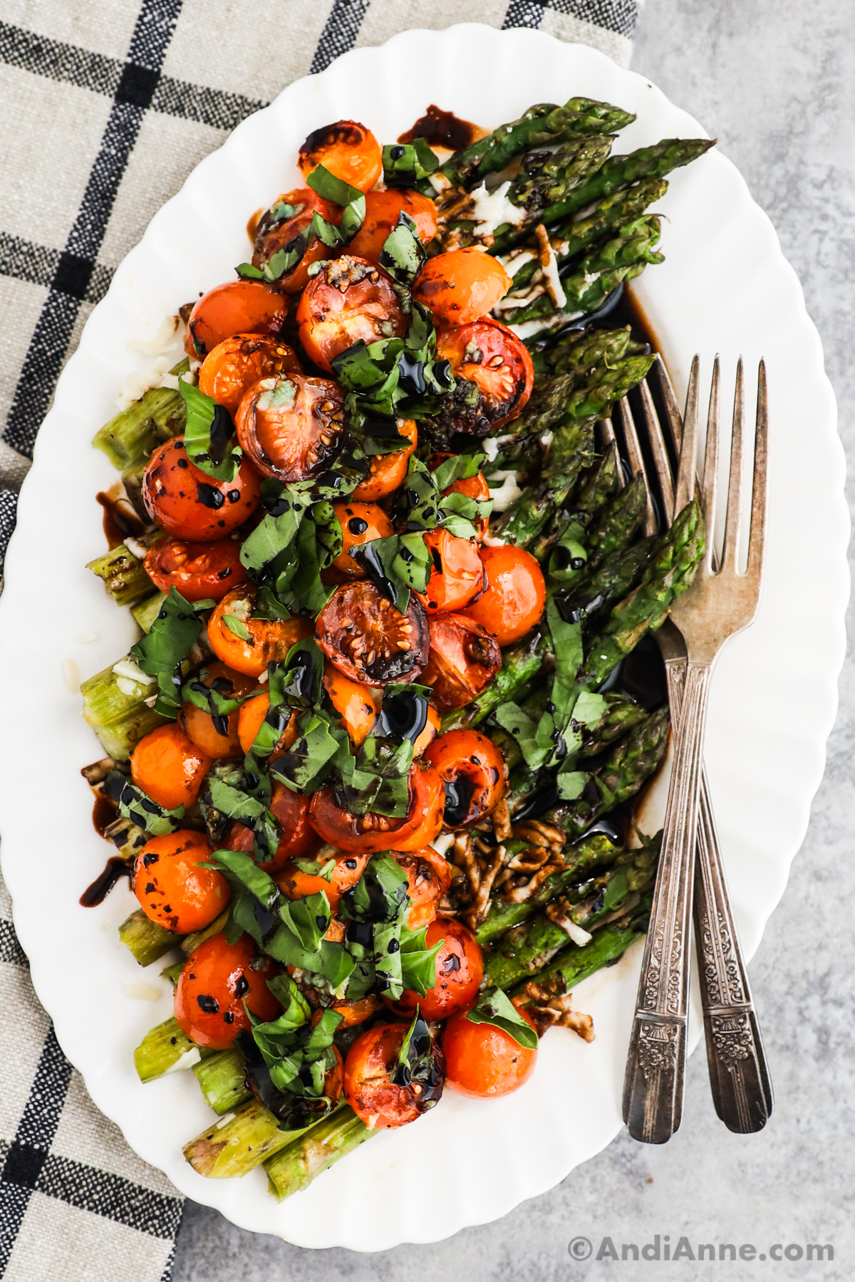 A plate of balsamic cherry tomatoes and asparagus with basil