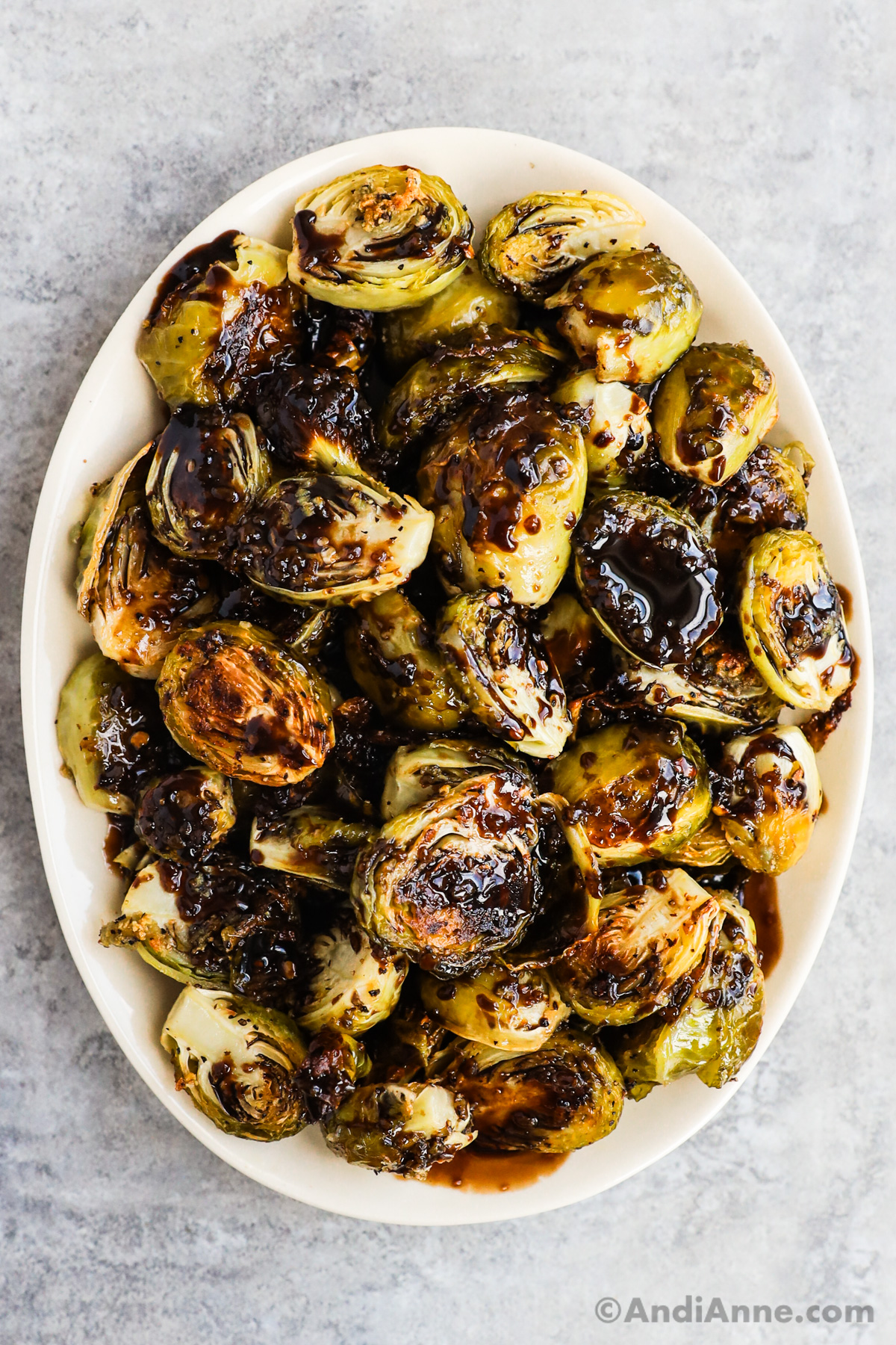 A plate of honey balsamic brussels sprouts drizzled with balsamic glaze