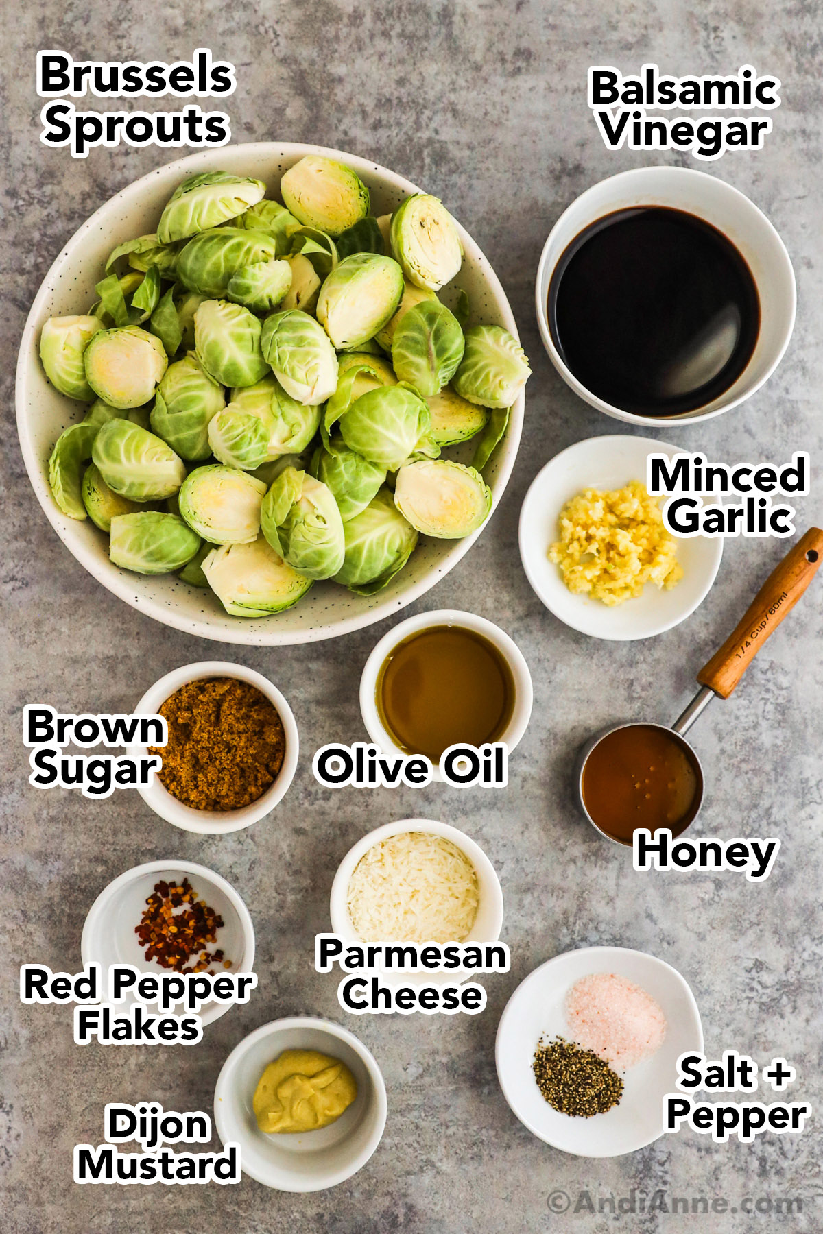 Recipe ingredients in bowls on counter including sliced brussels sprouts, bowls of balsamic vinegar, brown sugar, olive oil, honey, parmesan cheese, red pepper flakes, salt and pepper and dijon mustard.