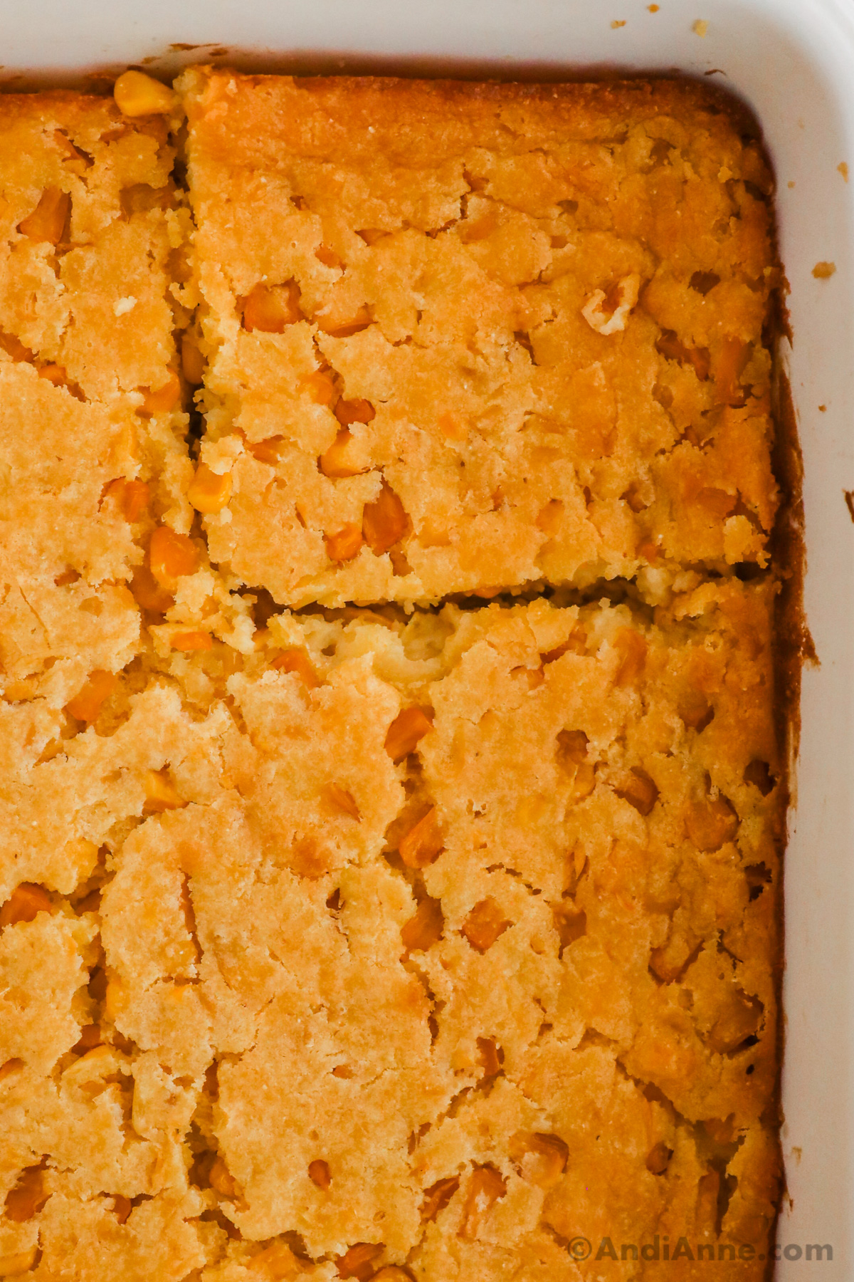 Close up of baked jiffy corn casserole in a white dish