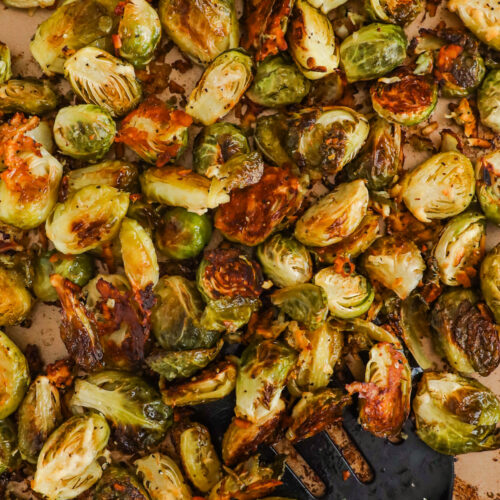 Sheet pan with garlic parmesan brussels sprouts and a spatula