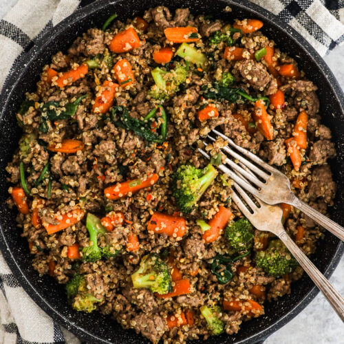 A frying pan with quinoa beef and broccoli recipe and two forks