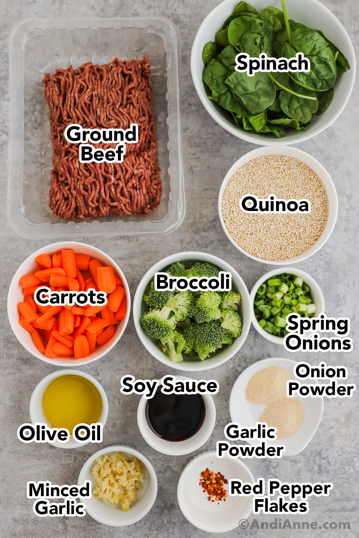 Recipe ingredients in containers including carton of ground beef, bowls of spinach, quinoa, chopped carrots, chopped broccoli, chopped onions, soy sauce, olive oil, garlic powder and minced garlic.