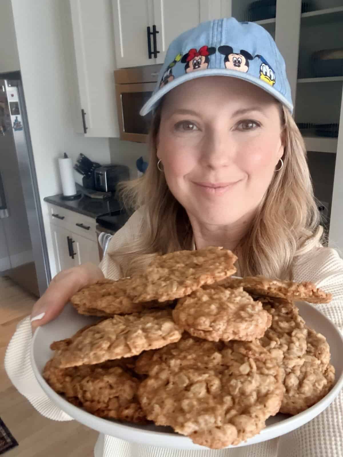 Andi is holding a plate of oatmeal cookies.