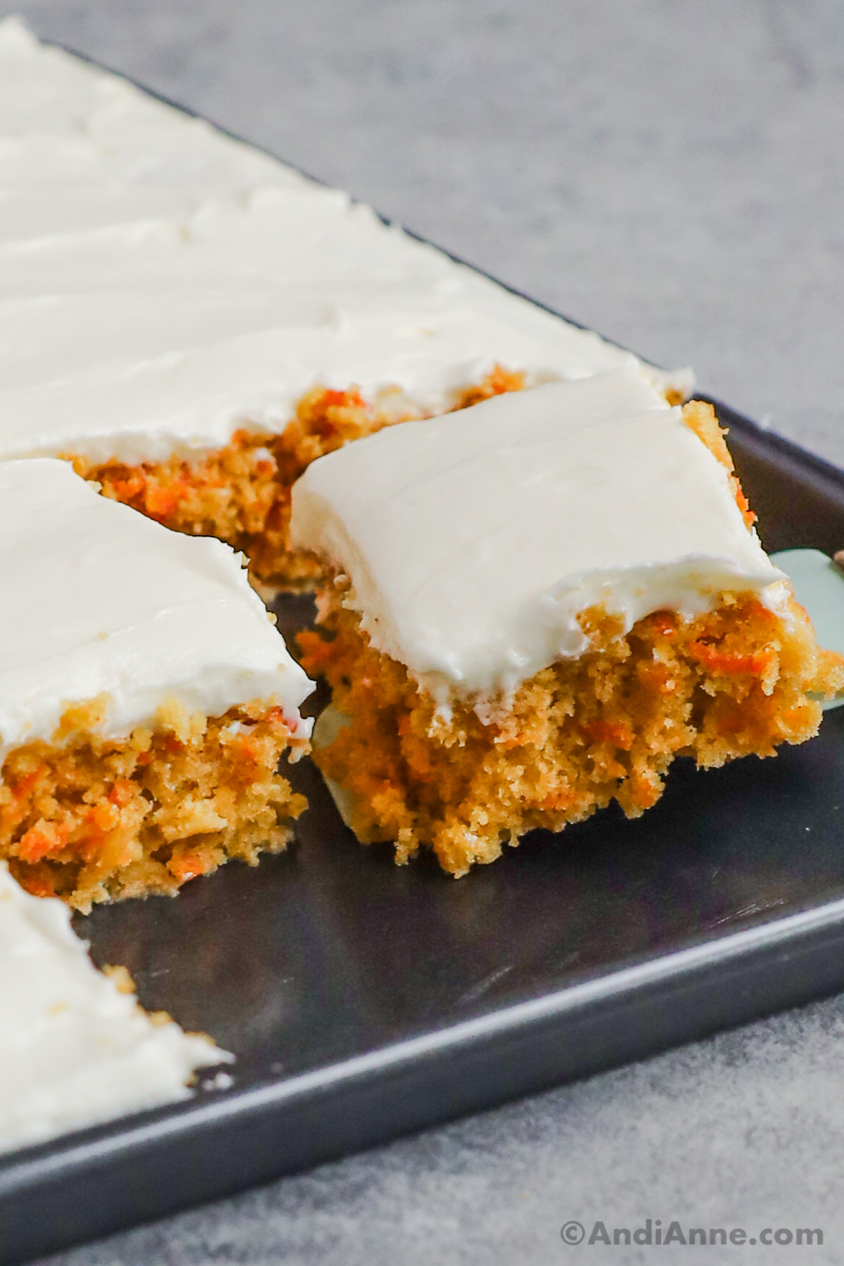 Close up of a slice of carrot cake with cream cheese frosting.