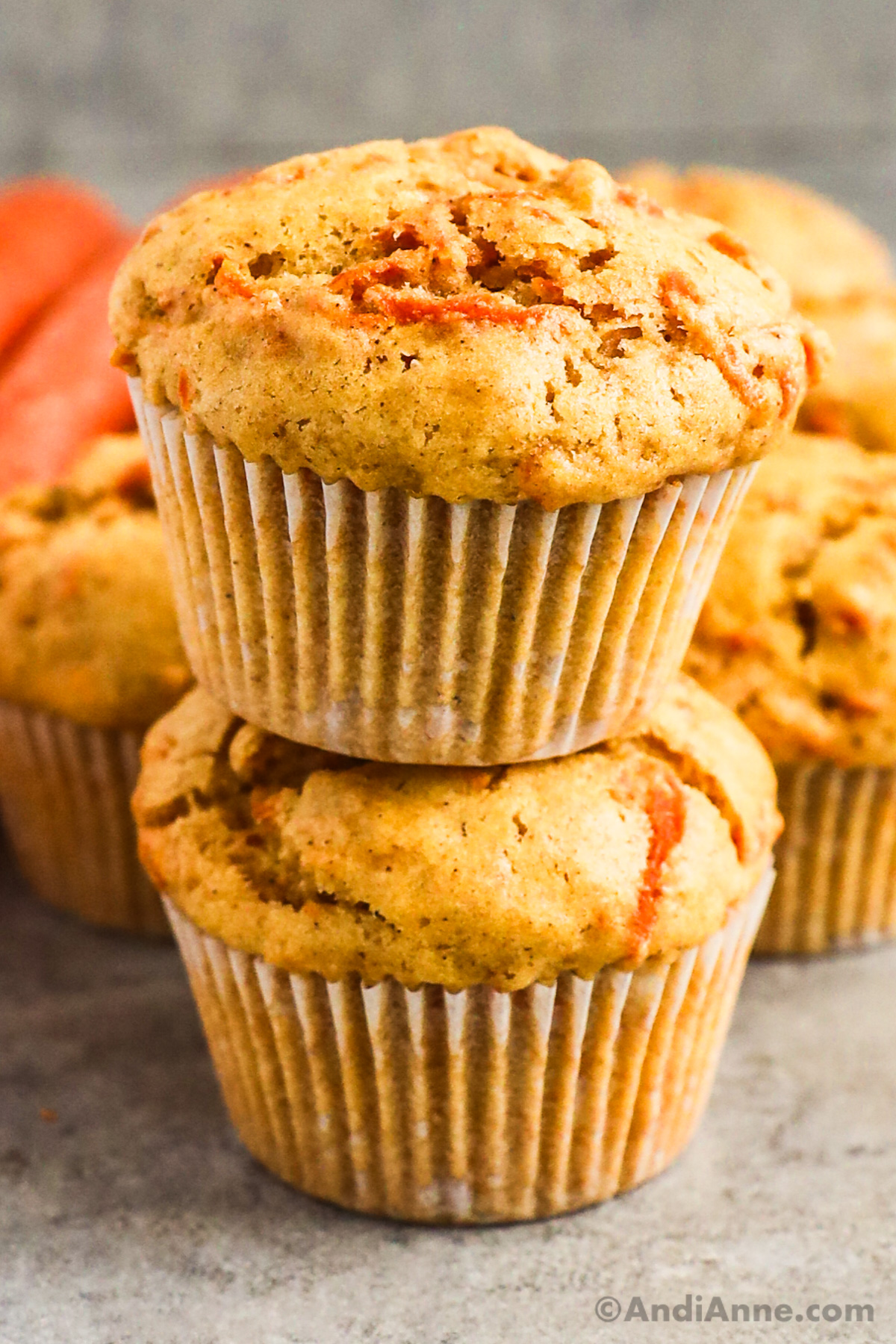 two carrot muffins stacked on top of eachother