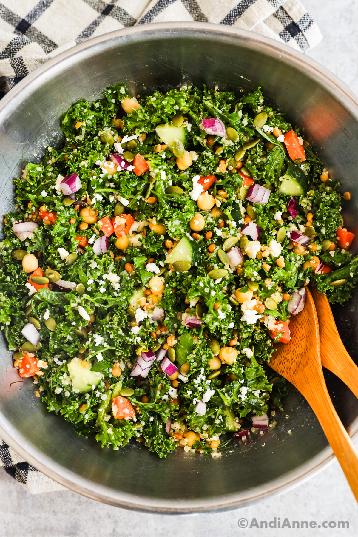 Close up of kale chickpea quinoa salad with two wood spoons