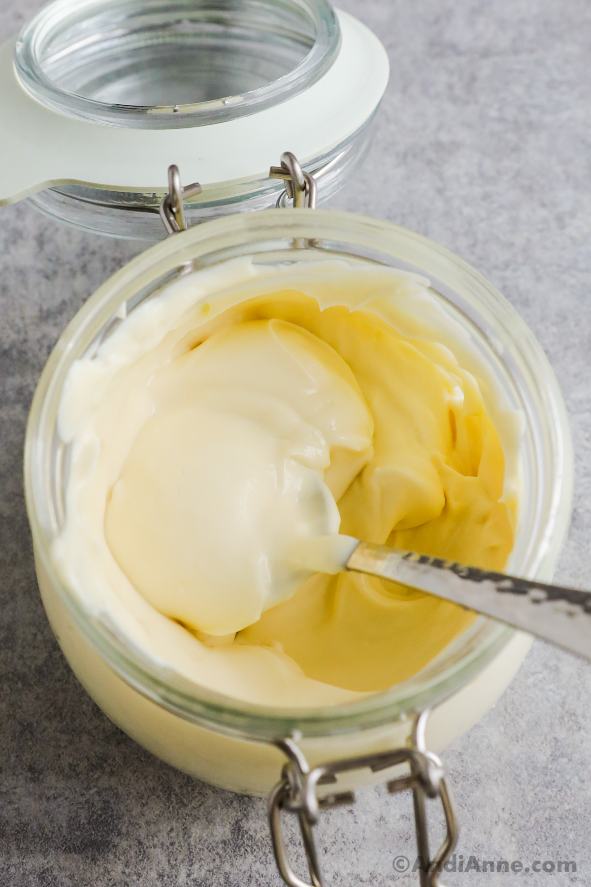 A jar of homemade mayonnaise with a spoon.