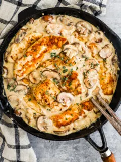 A pan with chicken in creamy mushroom sauce