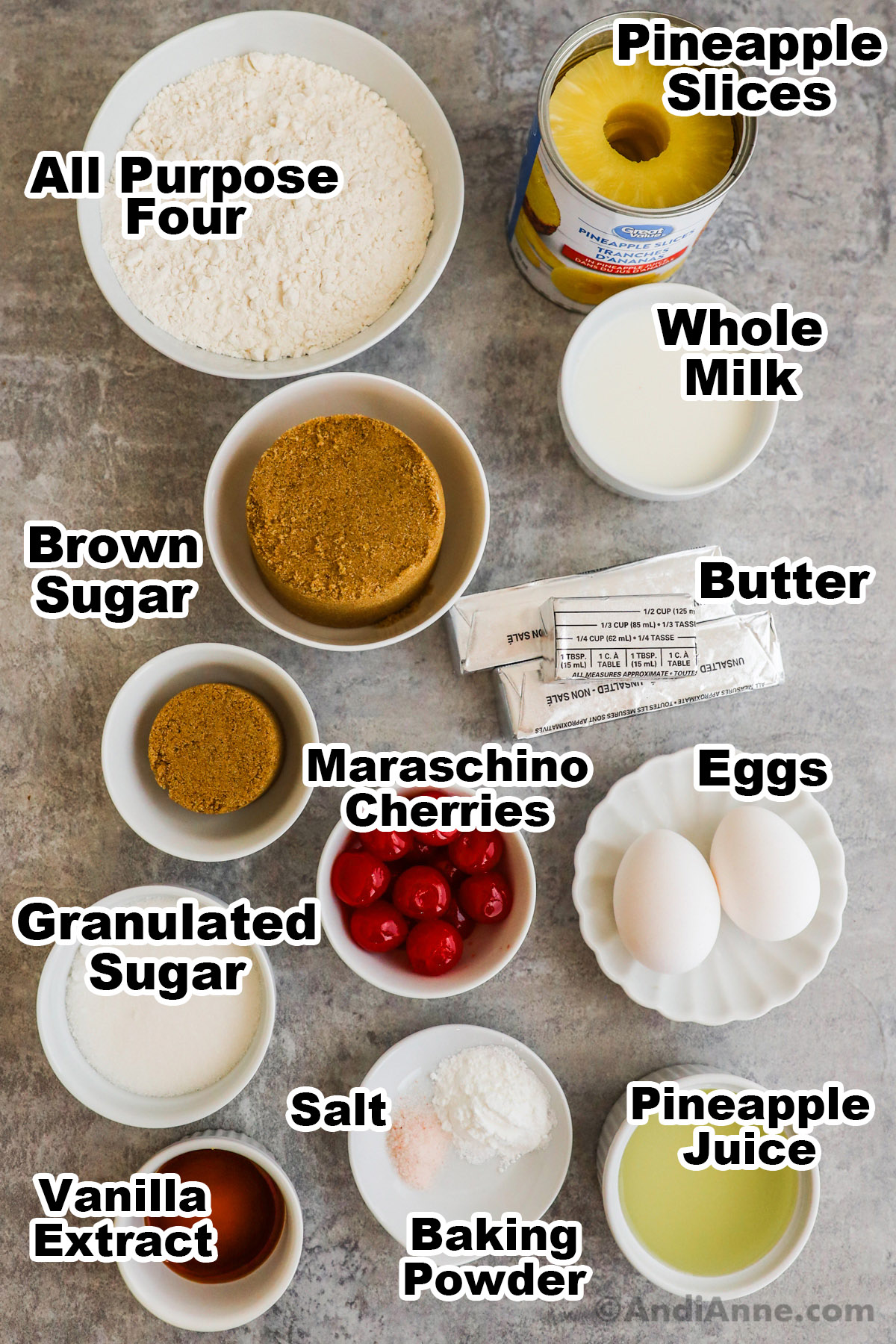 Recipe ingredients in bowls including flour, milk, brown sugar, butter, cherries, eggs, sugar, pineapple juice and canned pineapple.