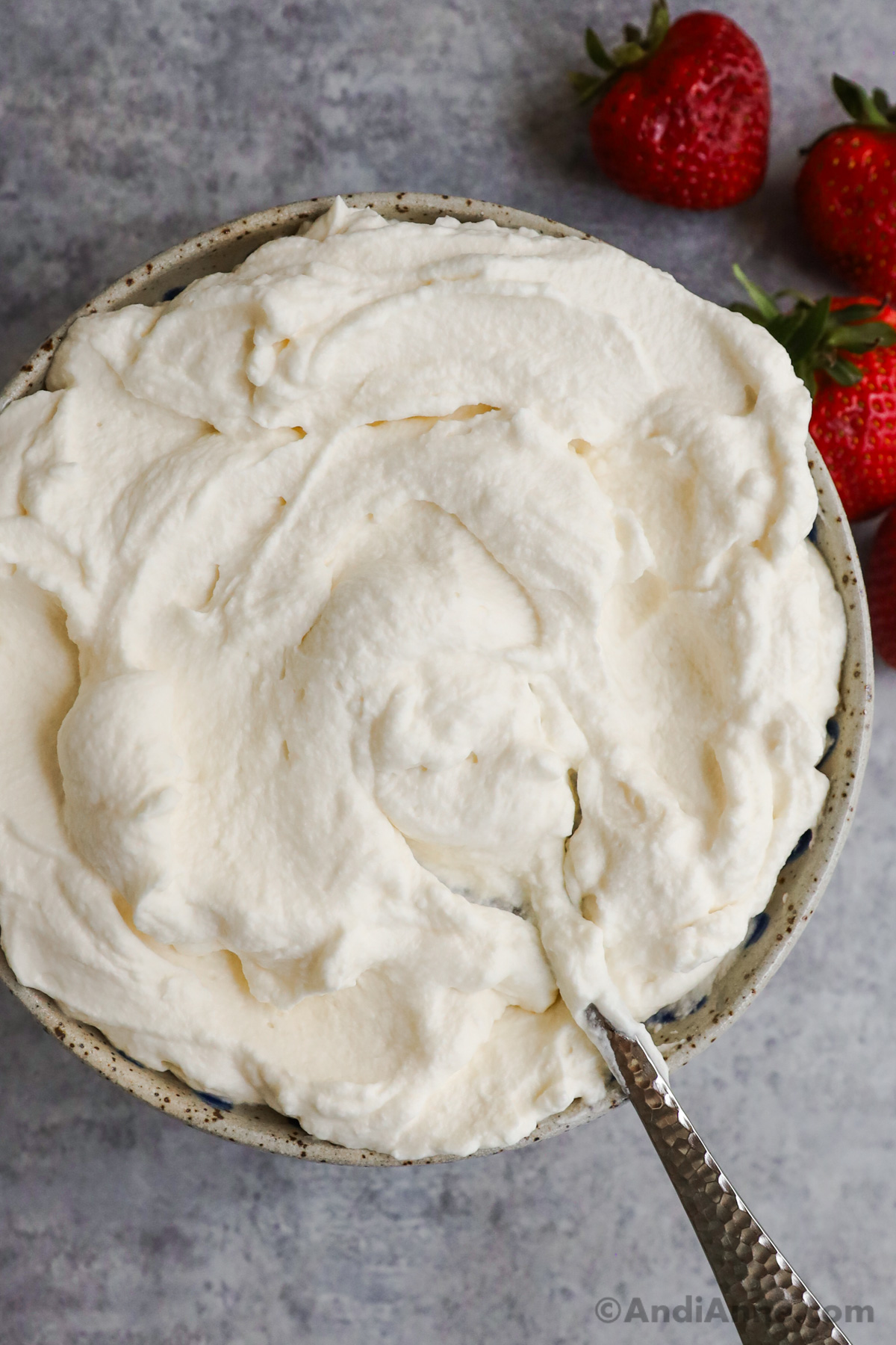 A bowl of whipped cream with a spoon.