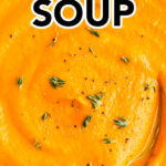 Close up of a bowl of creamy carrot soup with a spoon