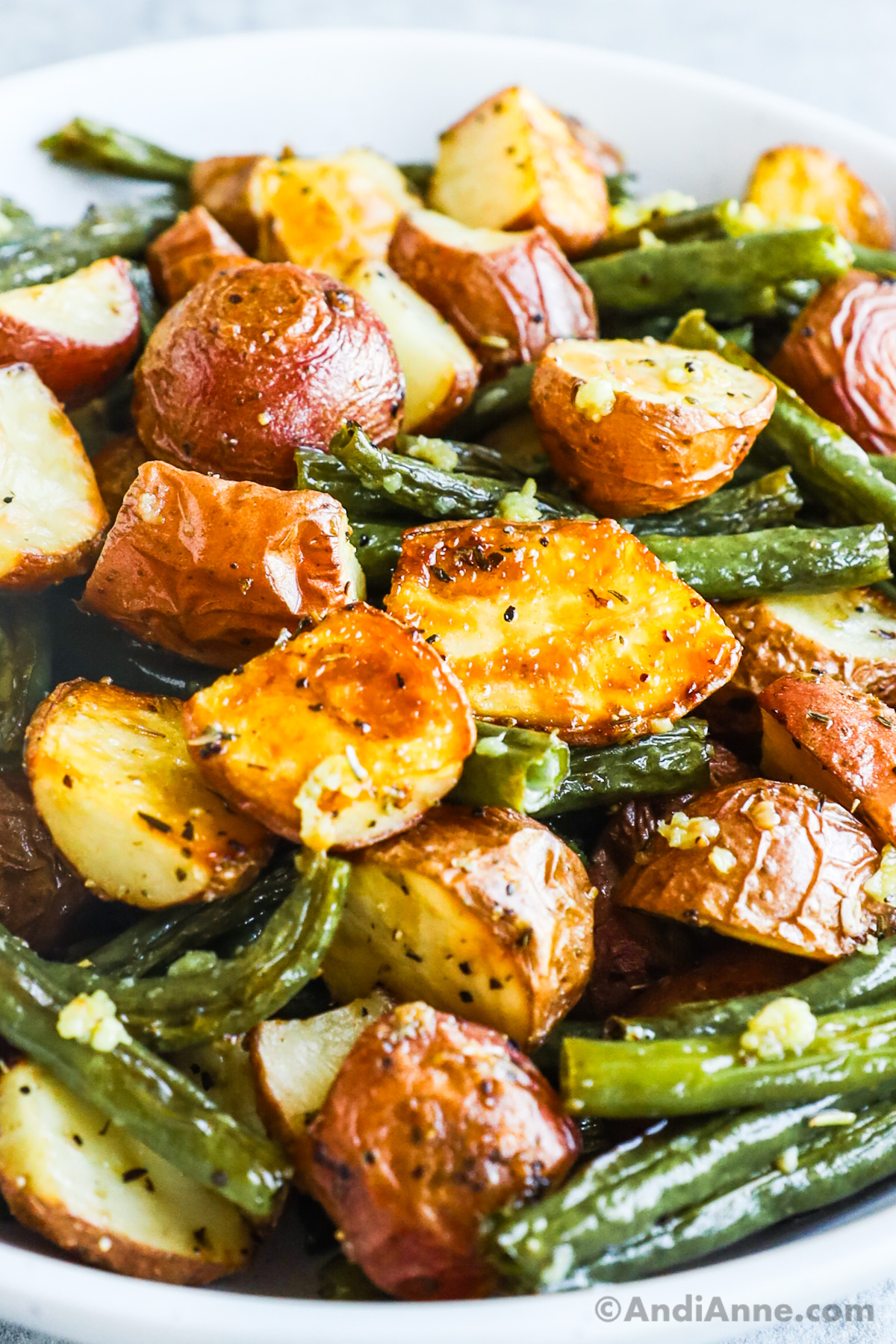 Close up of baked baby potatoes and green beans.