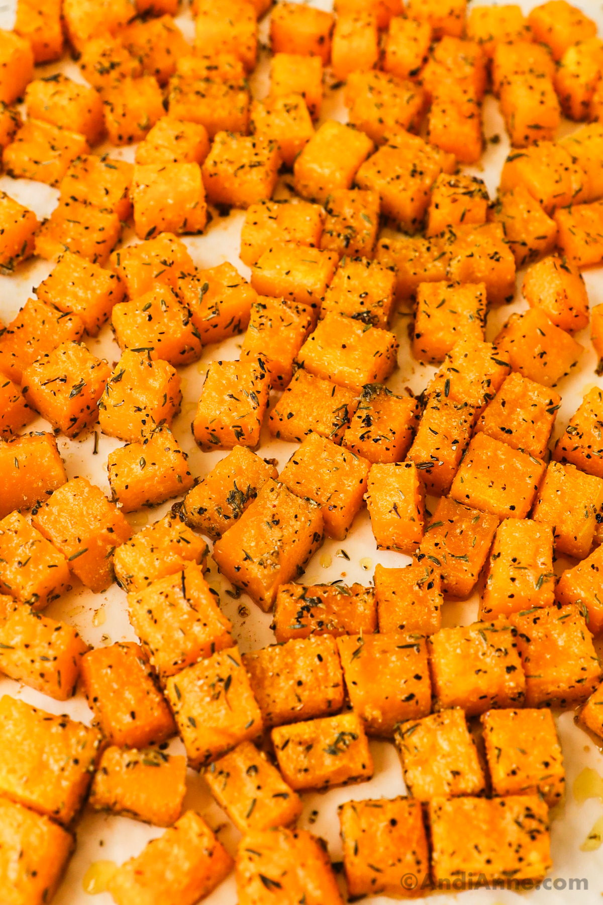 Close up of squash cubes on a baking sheet.