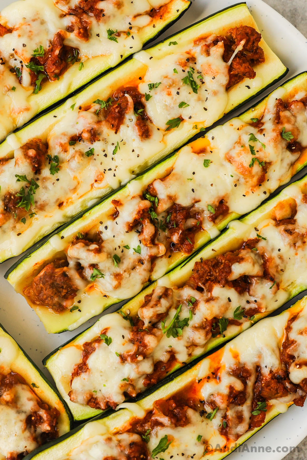 Close up of stuffed zucchini with ground beef and melted cheese.