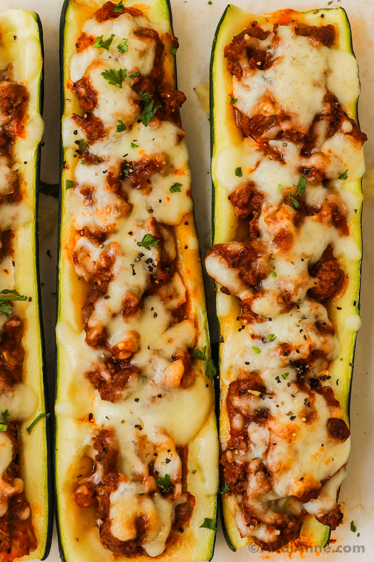 Close up of zucchini boats with ground beef and melted mozzarella in the middle.