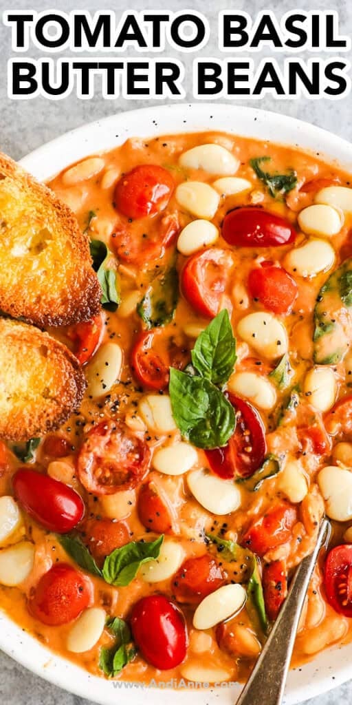 A bowl of tomato basil butter beans recipe with two bread slices on the side