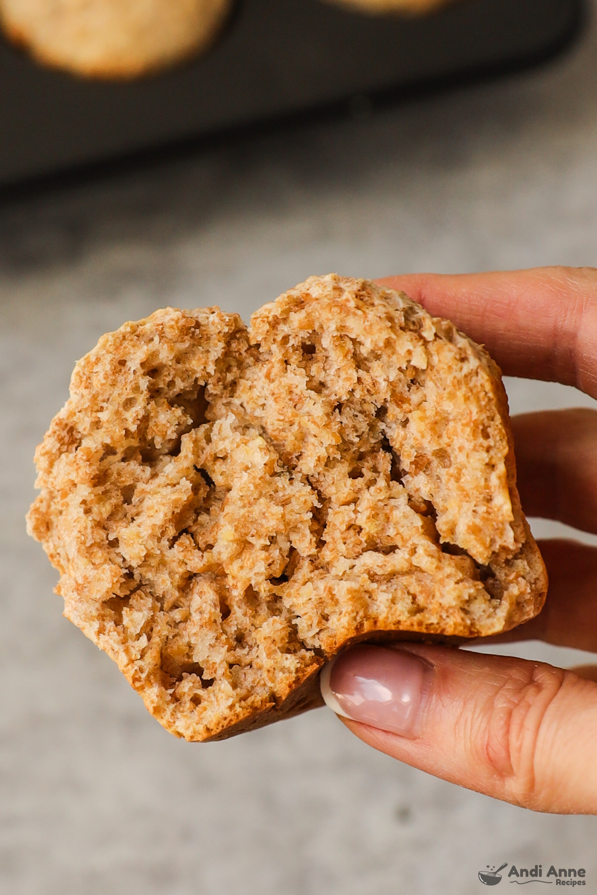 hand holding half of a bran muffin