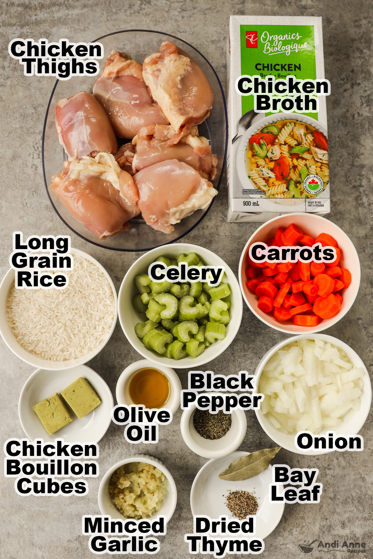 Recipe ingredients in bowls including raw chicken thighs, carton of chicken broth, bowls of rice, celery, carrots, chopped onion, bouillon cubes, olive oil, and minced garlic.