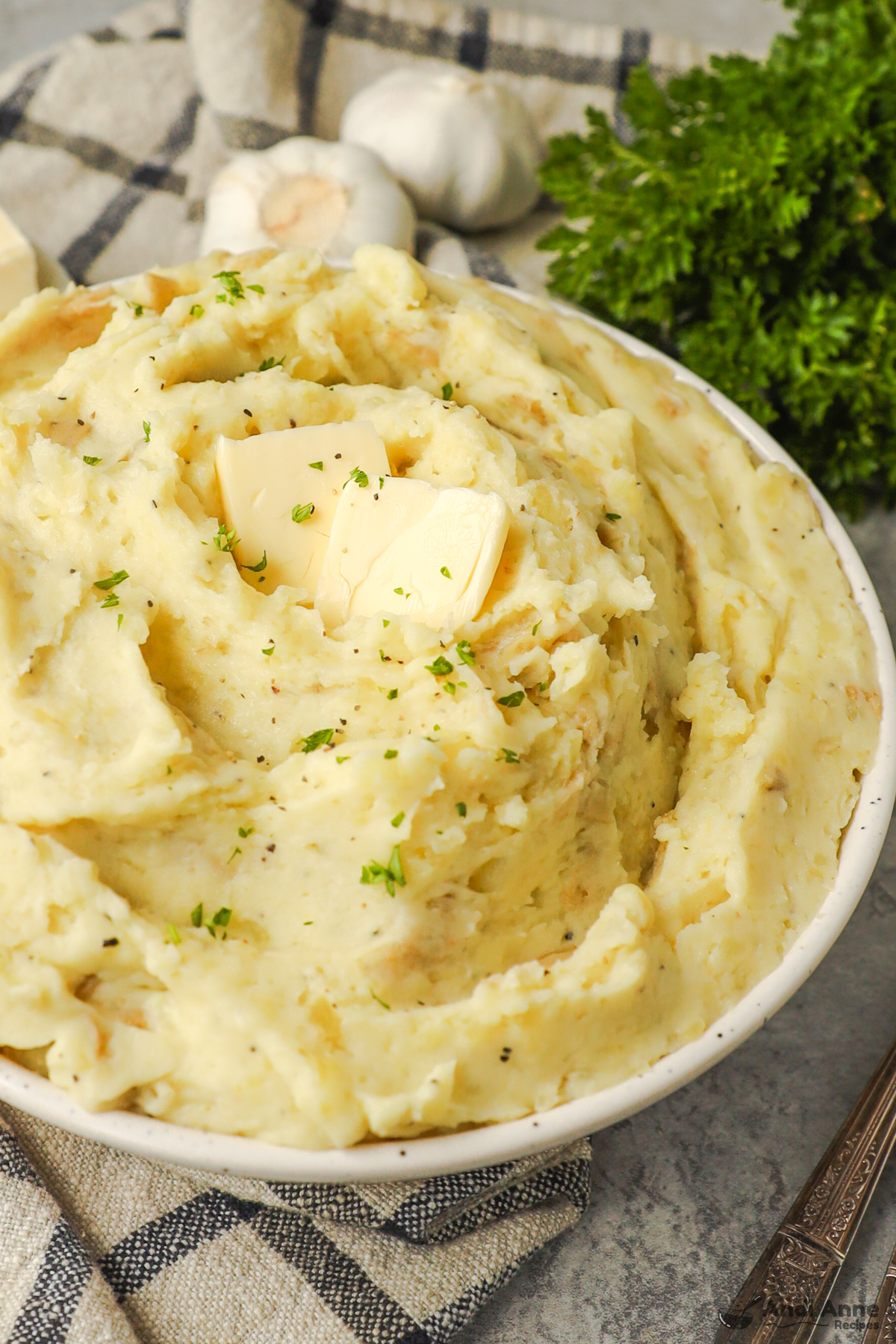 Close up of bowl of creamy mashed potatoes with a bit of butter.