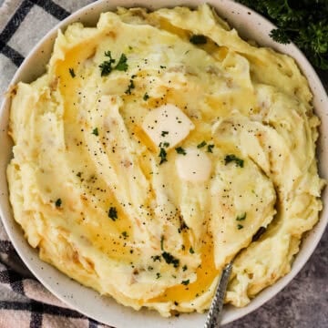 A plate of garlic mashed potatoes topped iwth butter