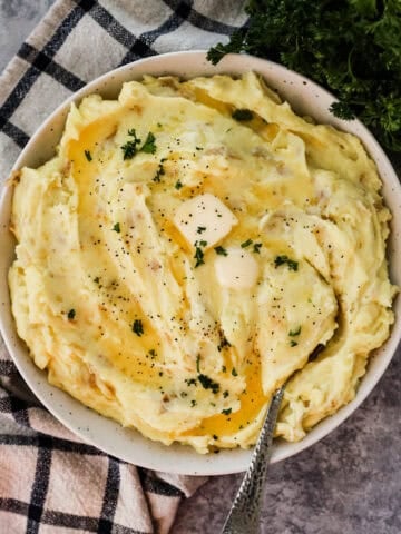 A plate of garlic mashed potatoes topped iwth butter