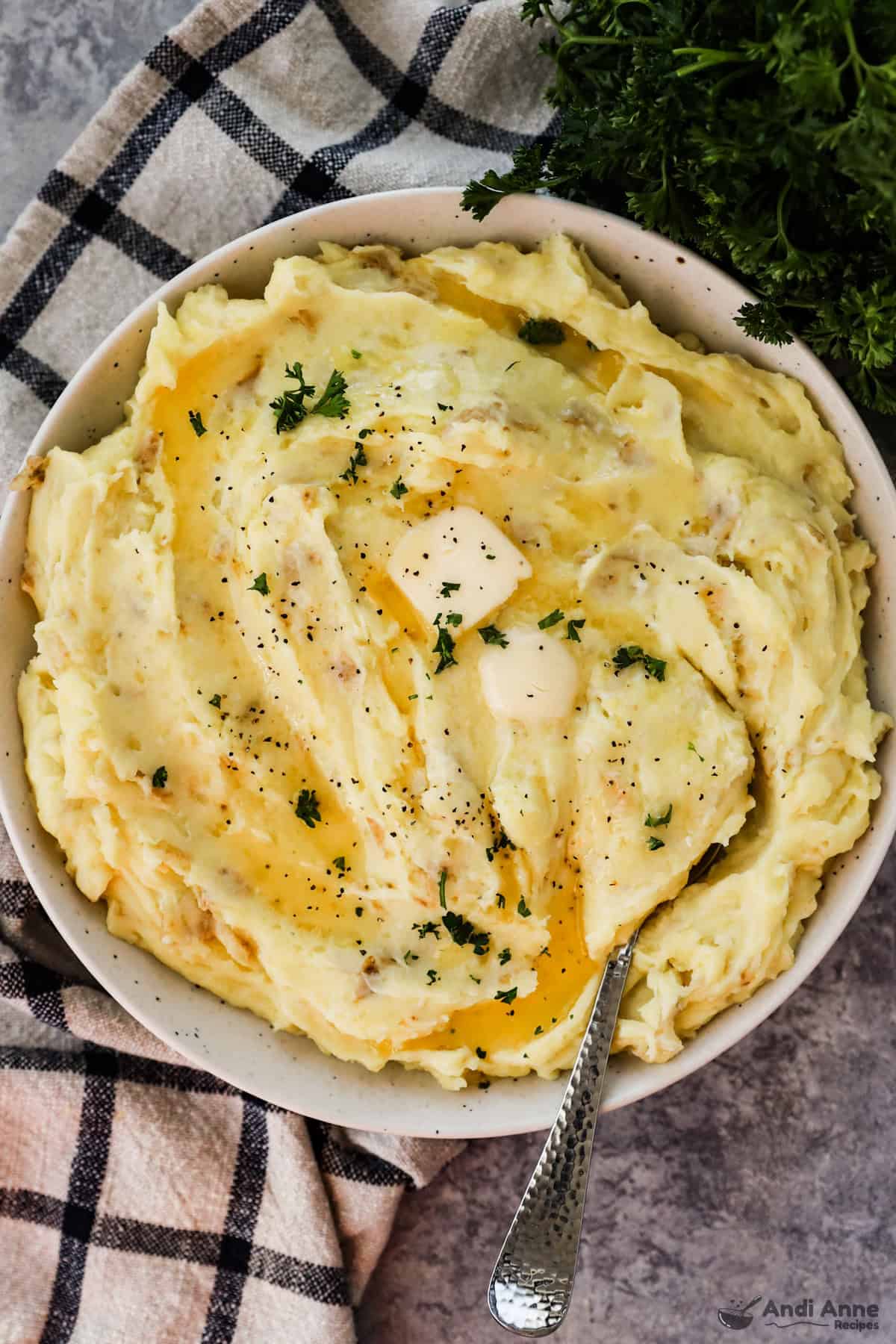A plate of garlic mashed potatoes topped iwth butter 
