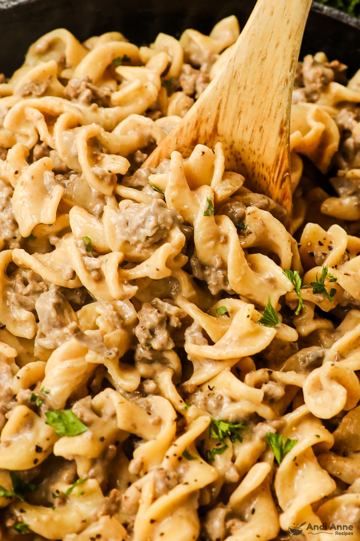 Close up of ground beef stroganoff with a wood spoon