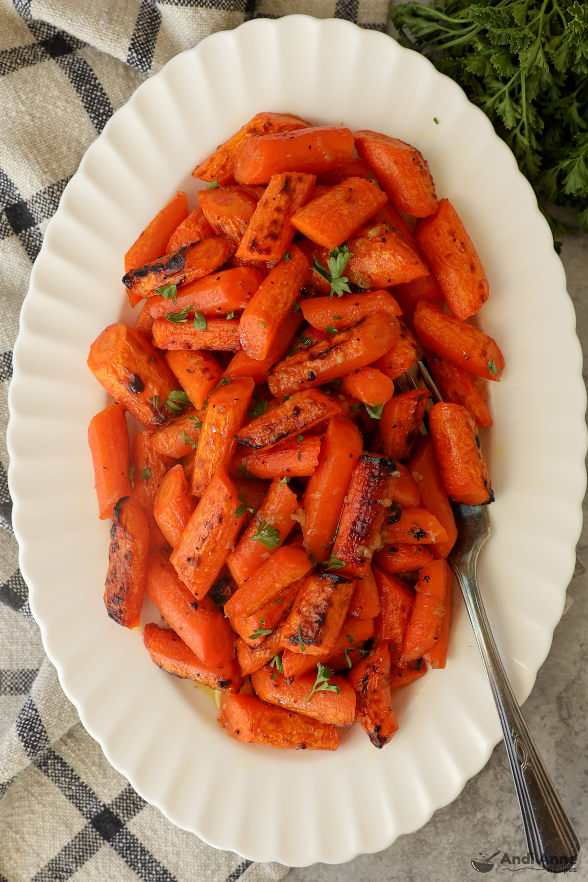 Close up of a plate of honey garlic butter carrots with a fork