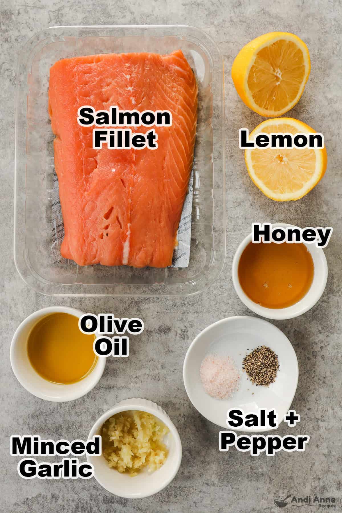 A salmon fillet, sliced lemon, bowls of honey, olive oil, minced garlic, salt and pepper