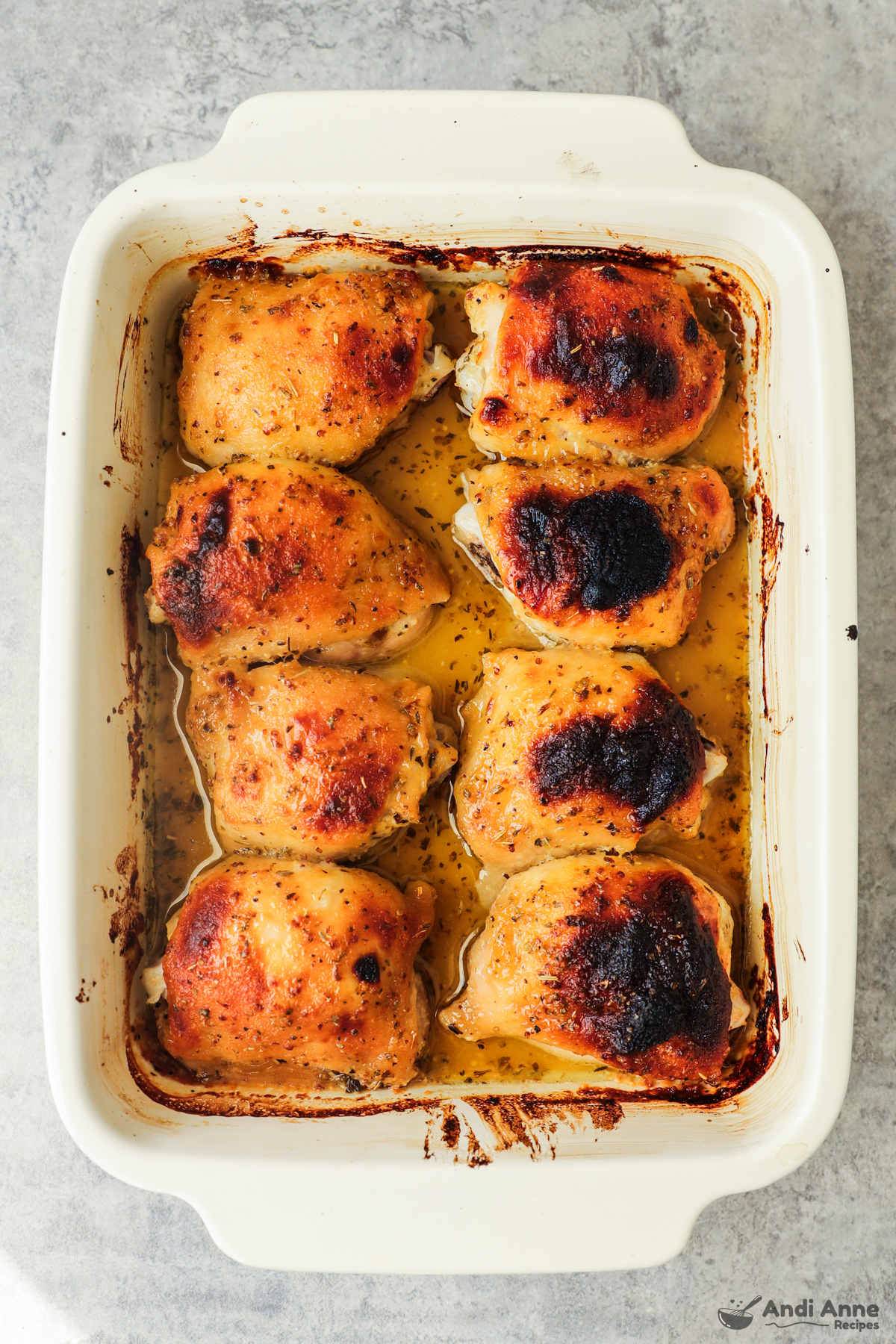 Cooked honey mustard chicken thighs in a baking dish.