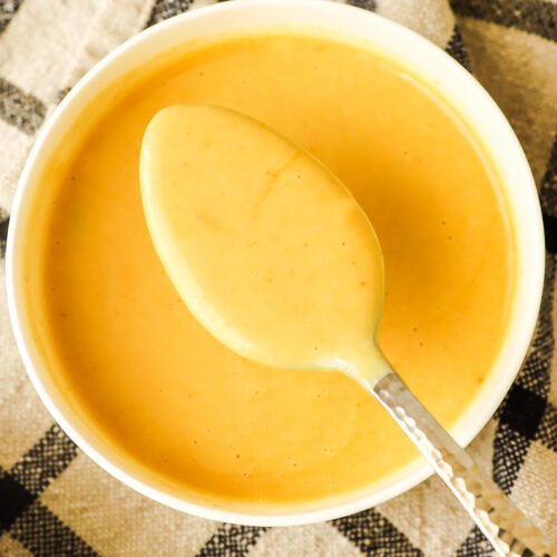 a bowl of honey mustard sauce with a spoon