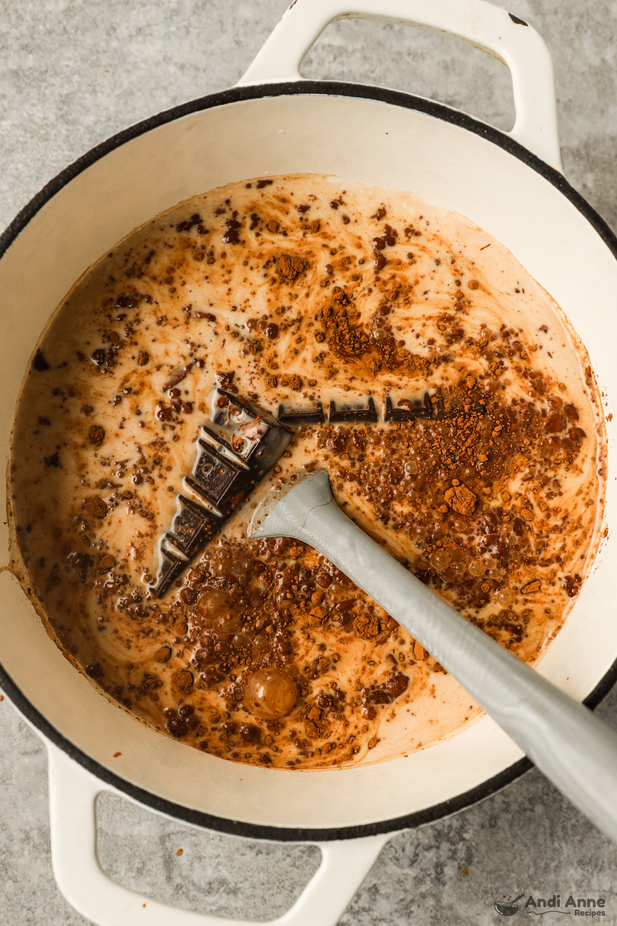 White pot with milk, cocoa powder, and chocolate. 