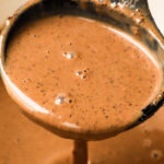 A soup ladle scooping thick and creamy hot chocolate