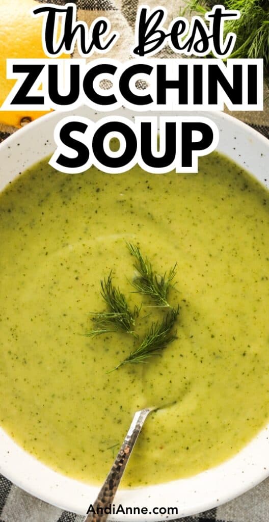 A bowl of creamy zucchini soup topped with fresh dill and a spoon