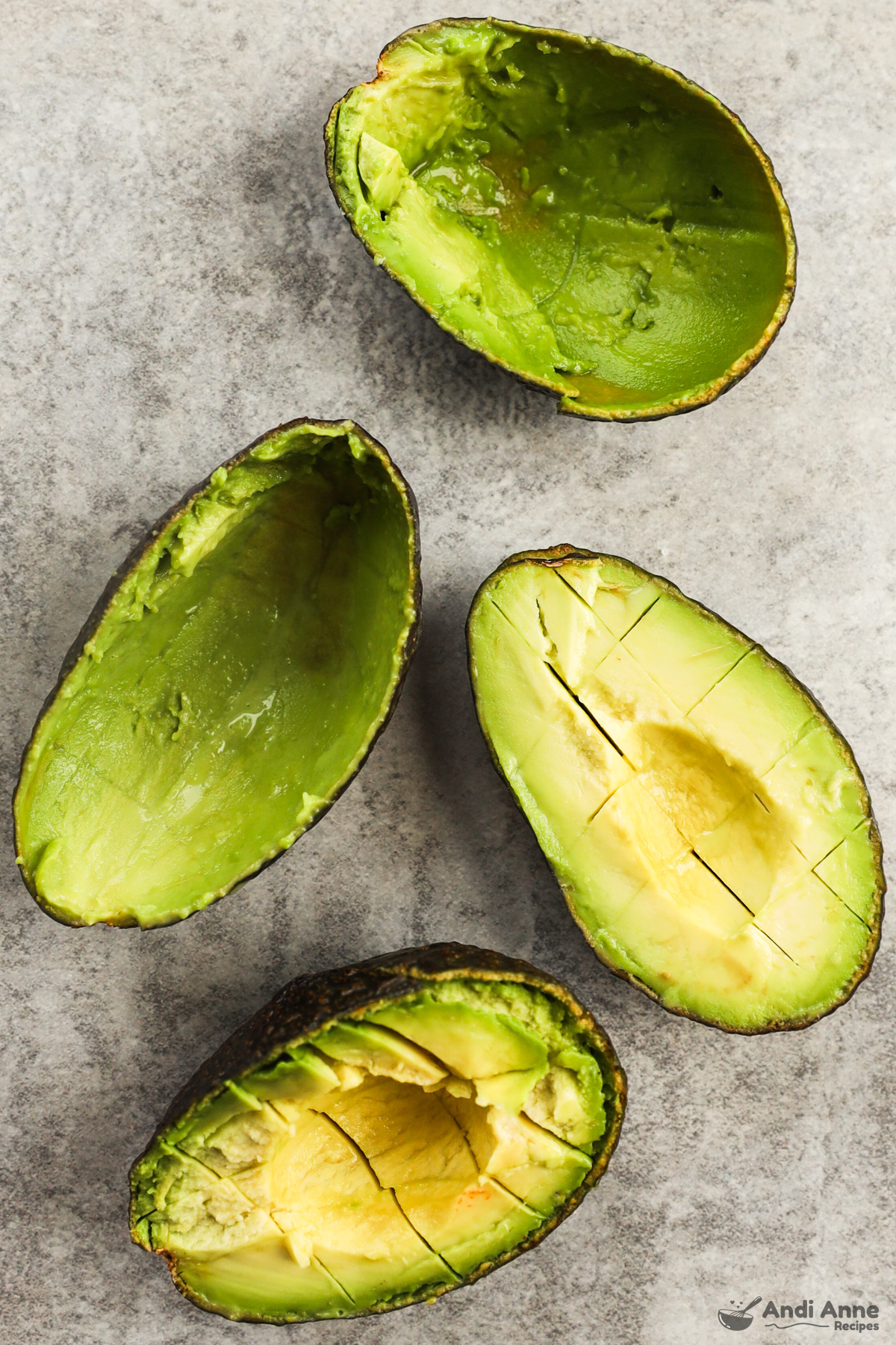 one avocado with flesh scooped out, second with avocado cubed