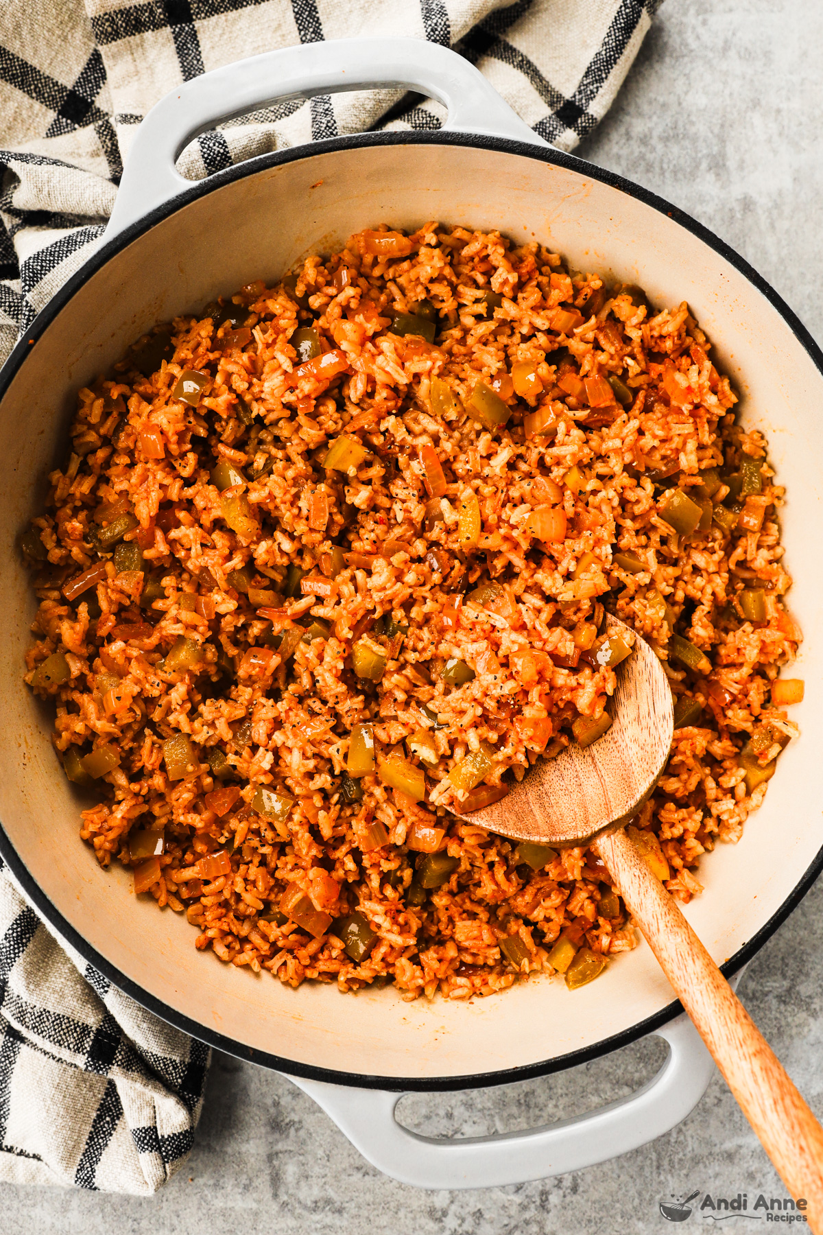 A pot with cajun rice recipe and a wood spoon