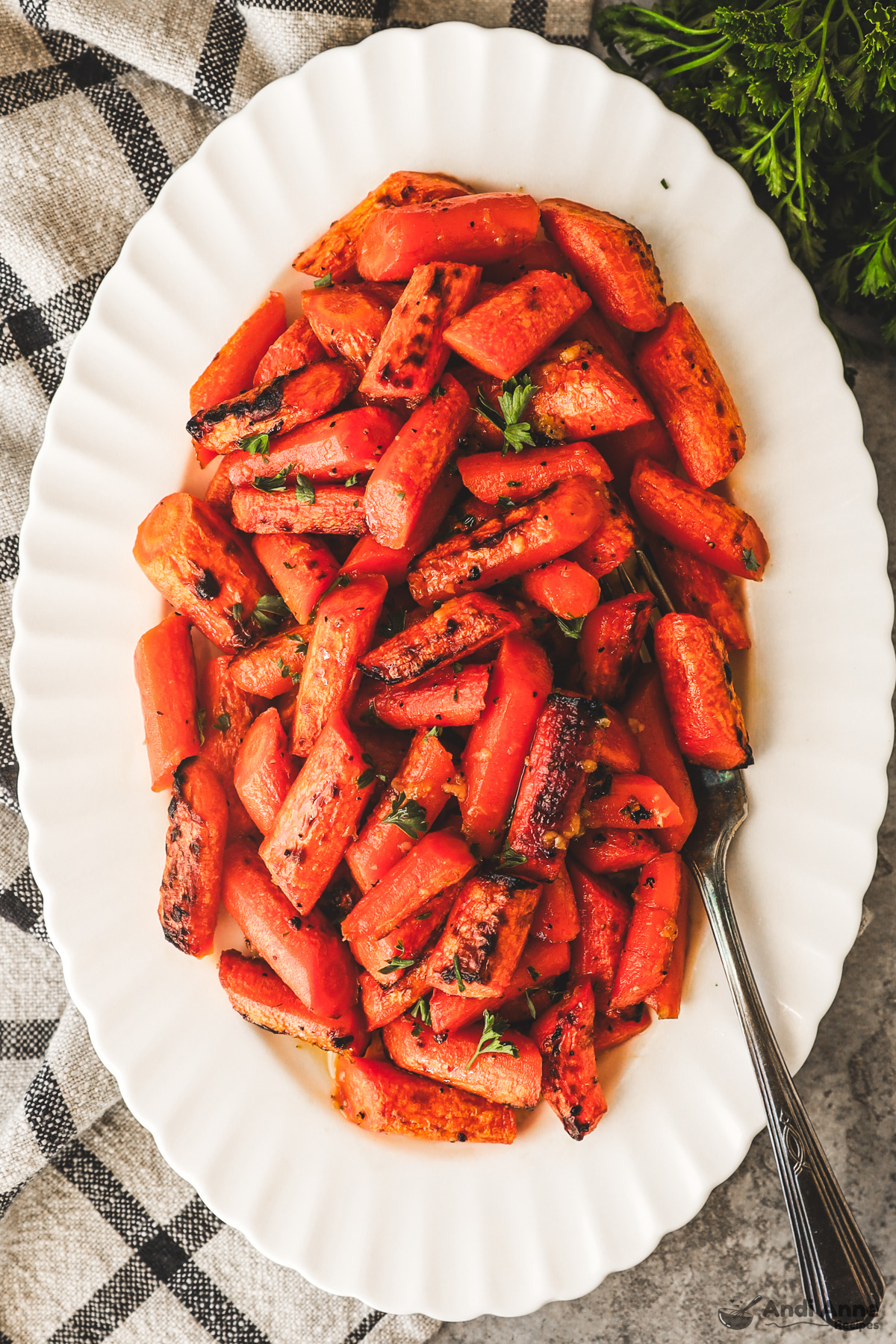 Close up of a plate of honey garlic butter carrots with a fork